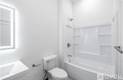 A white bathroom with a toilet, sink, and bathtub.