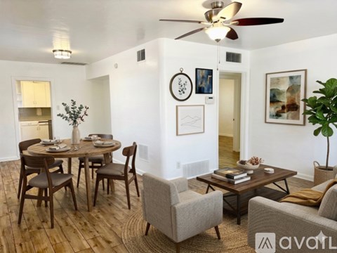 A living room with a dining table and chairs.