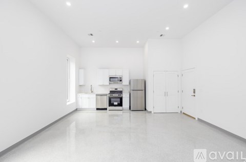 A spacious kitchen with white appliances and cabinets.