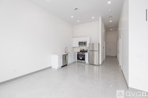 A spacious kitchen with white appliances and cabinets.