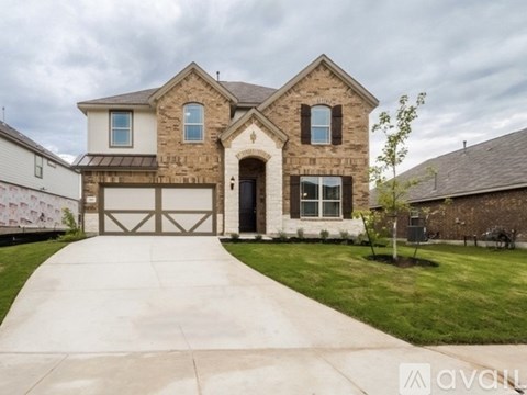 A two-story house with a garage and a driveway.