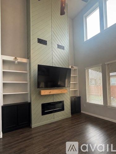 A living room with a flat screen TV mounted above a fireplace.