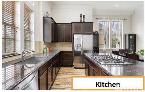 A kitchen with dark wood cabinets and a stainless steel sink.