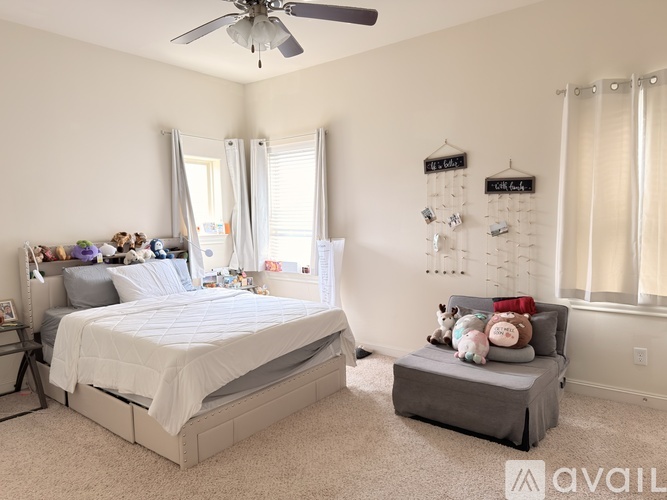 A bedroom with a bed, a bench, and a fan.