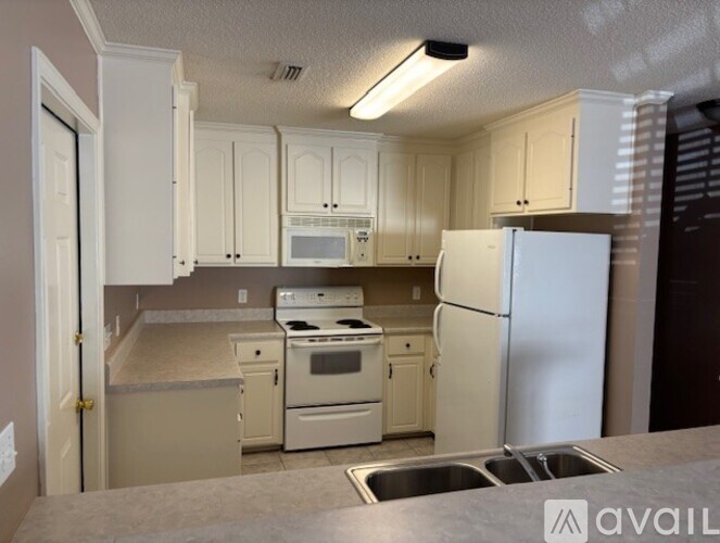 A kitchen with white appliances and cabinets.