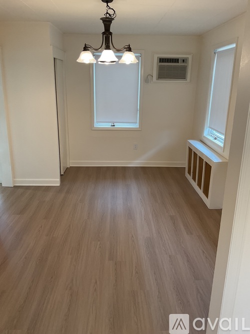 A room with wooden flooring and a chandelier.