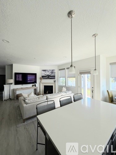 A modern living room with a white couch and a television.