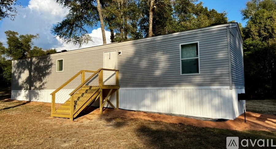 A silver house with a yellow staircase leading to a door.