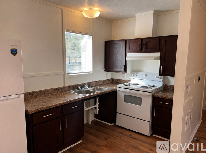A kitchen with a white stove and brown cabinets.