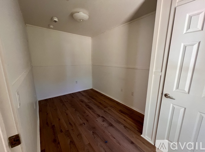 A room with wooden floors and white walls.