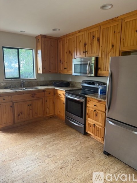 A kitchen with wooden cabinets and a refrigerator.