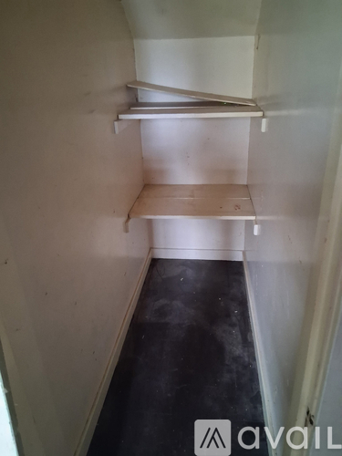 A white shelf in a room with a black floor.