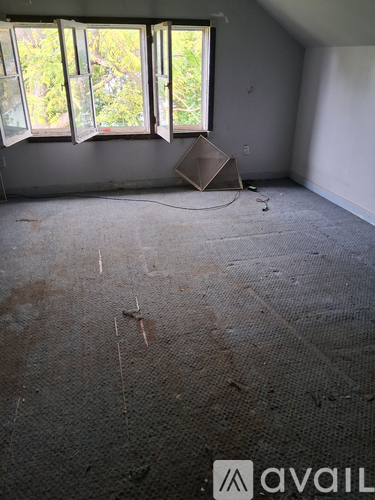 A room with a carpeted floor and a large window.