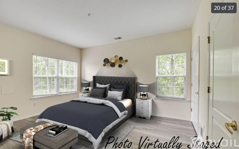 A bedroom with a large bed and a window with blinds.