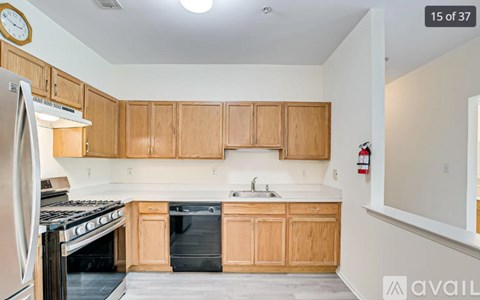 A kitchen with wooden cabinets and a white stove top oven.