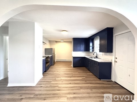 A kitchen with dark blue cabinets and a white door.
