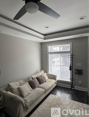 A living room with a couch and a ceiling fan.