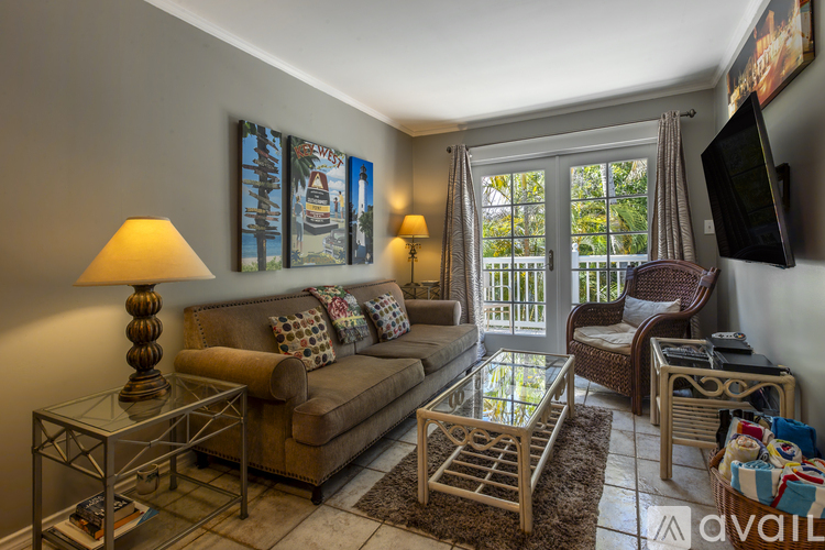 A living room with a couch, chair, and a television.