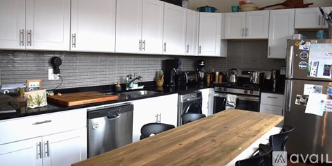 A kitchen with a wooden table in the middle of it.