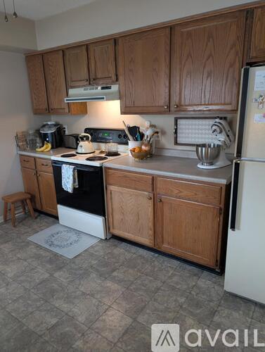 A kitchen with wooden cabinets and a black stove top oven.