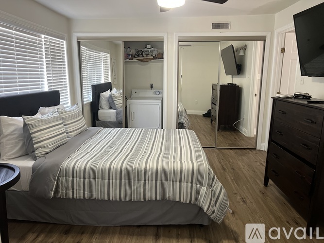 A bedroom with a bed, dresser, and mirror.