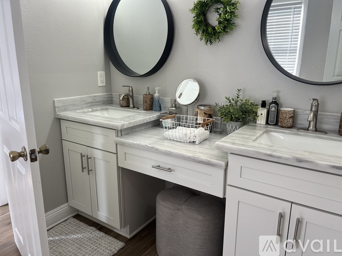 A bathroom with two sinks and a wreath on the wall.