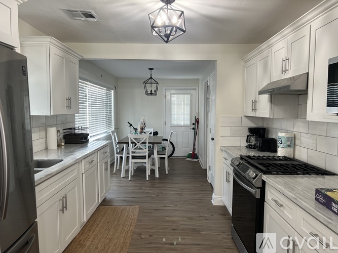 A kitchen with white cabinets and a wooden floor.