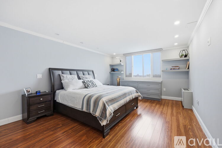 A bedroom with a large bed and wooden floors.