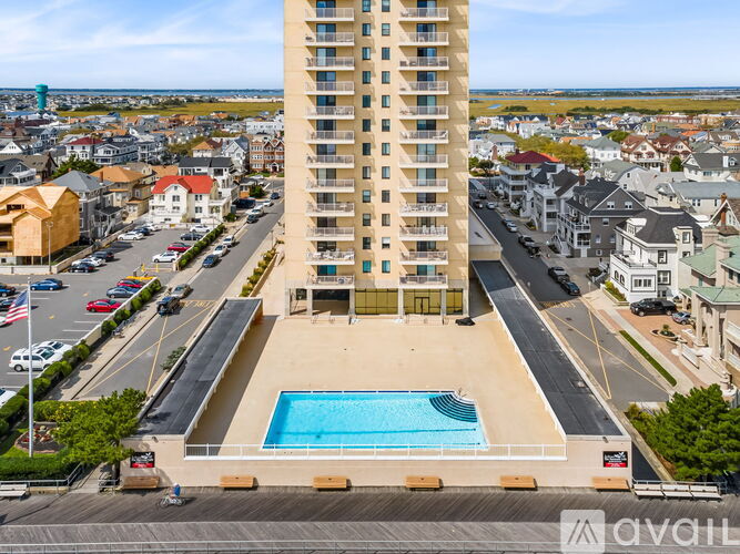 A tall building with a pool in front of it.