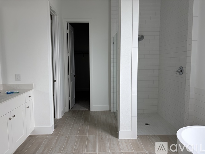 A bathroom with a white tub and a walk-in shower.