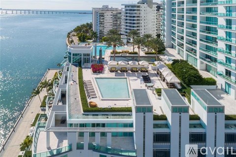 A view of a pool and beach from a high rise building.