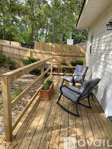 A wooden deck with two chairs and a planter box.