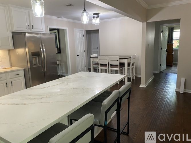 A kitchen with a marble table and stainless steel appliances.
