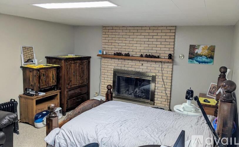 A bedroom with a fireplace and a bed.