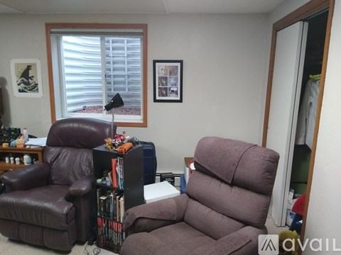 A living room with a brown leather chair and a brown leather couch.