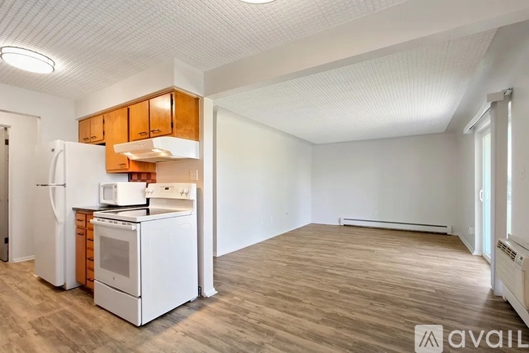 A kitchen with white appliances and wooden cabinets is available.