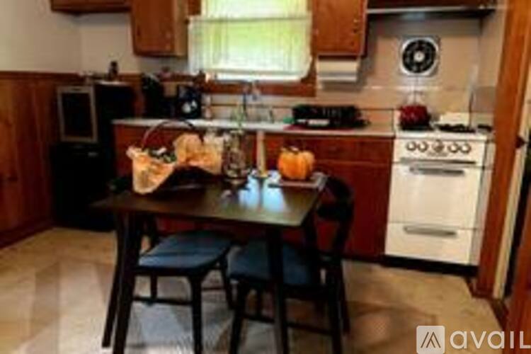 A kitchen with a table and chairs in the middle.