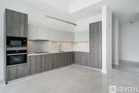 A modern kitchen with a dark wood finish and white cabinets.
