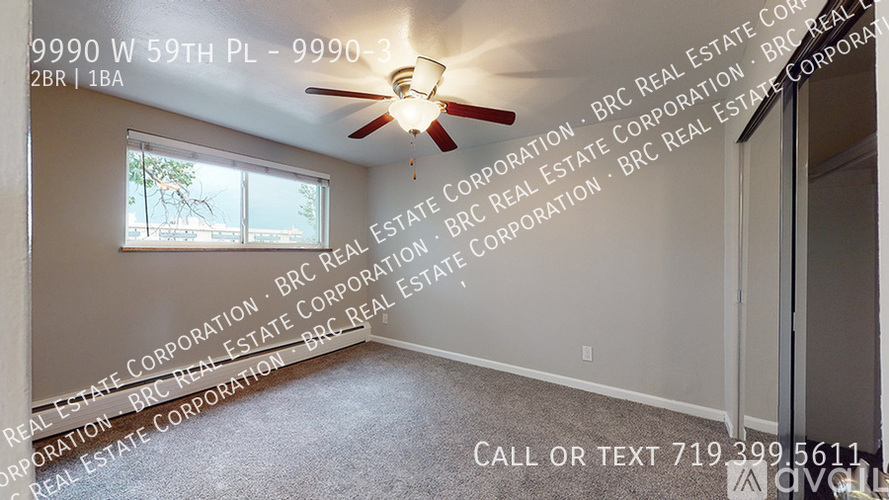 A room with a ceiling fan and a window, with the address 9990 W 59TH PL and the phone number 719 399 5611 displayed on the wall.