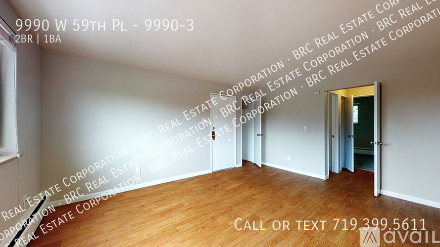 A room with a doorway leading to another room and a phone number on the wall.
