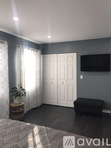 A bedroom with a large bed and a flat screen TV mounted on the wall.