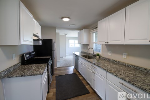 A kitchen with granite countertops and white cabinets.