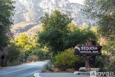 A sign for Sequoia National Park stands in front of a road.