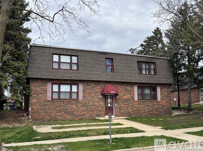A small brick house with a mailbox in front.