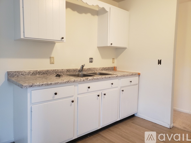 A kitchen with white cabinets and a granite countertop.