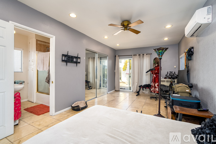 A bedroom with a large bed and a ceiling fan.