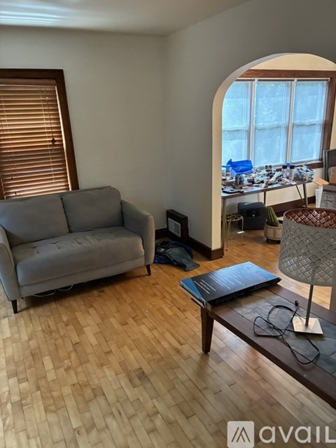 A living room with a grey couch and a wooden floor.