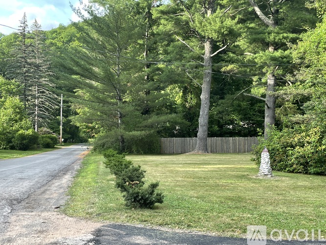 A road with a fence and trees on the side.