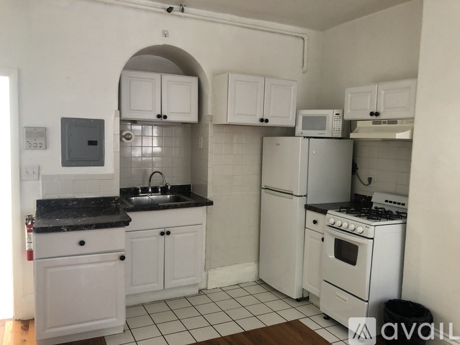 A kitchen with white appliances and cabinets.