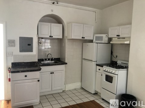 A kitchen with white appliances and cabinets.